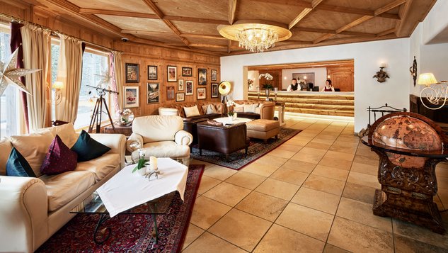 Luxuriöser Empfangsbereich mit Ledersofas und Holzverkleidung in der Lobby eines Hotels