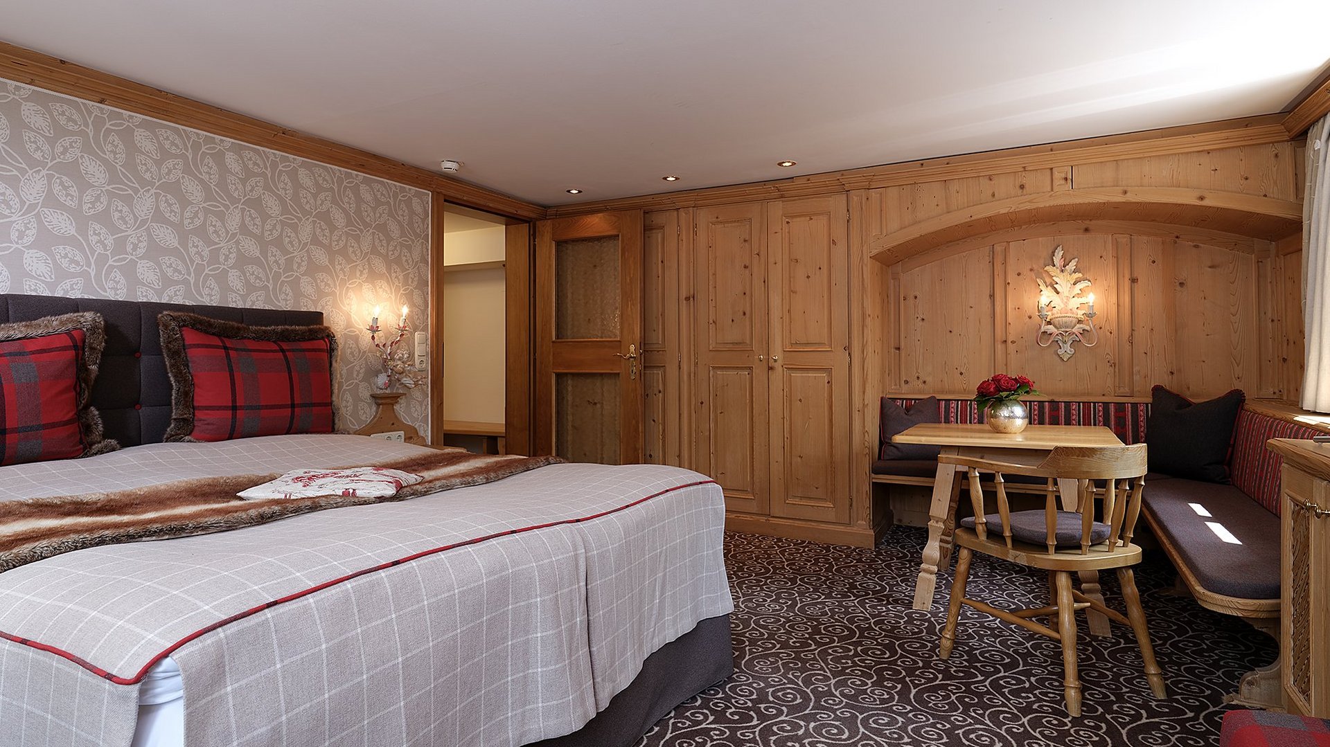 Cozy accommodation featuring a double bed, plaid decor, and a small seating area